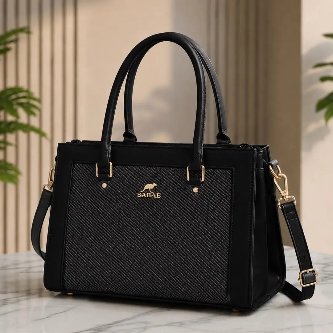The Woven Tote in Noir — front view with woven texture and gold hardware