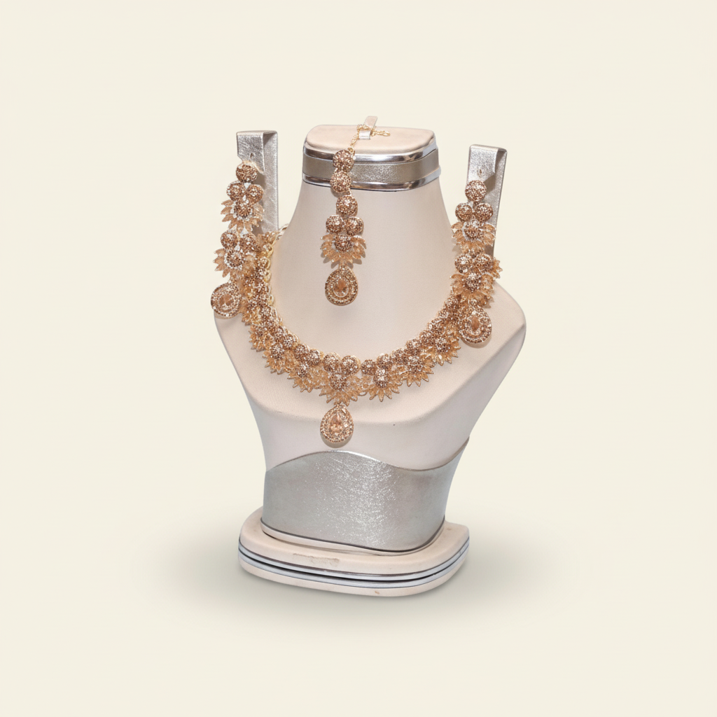Gold-plated crystal bridal jewelry set with floral necklace and matching earrings on an ivory jewelry bust