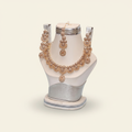 Gold-plated crystal bridal jewelry set with floral necklace and matching earrings on an ivory jewelry bust