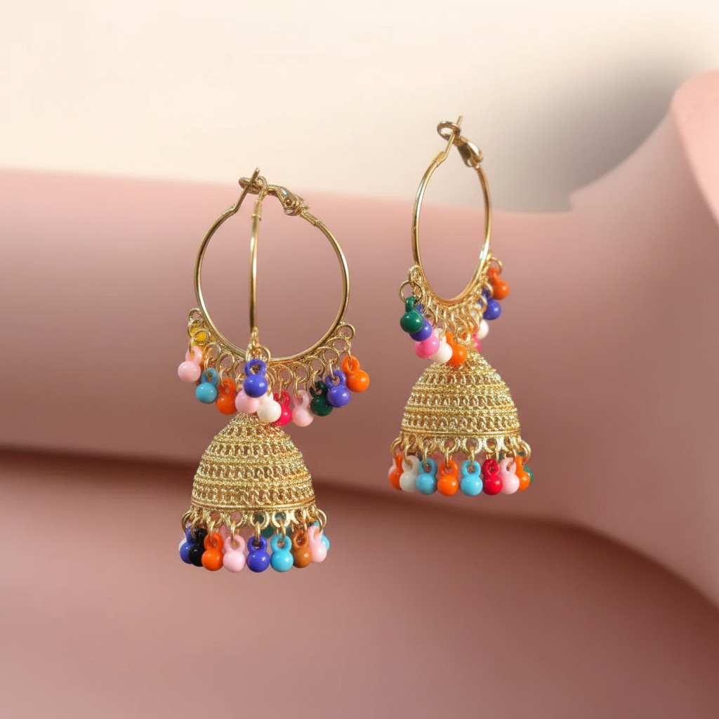 Close detail of ornate golden jhumka earrings with colourful crystal tassels