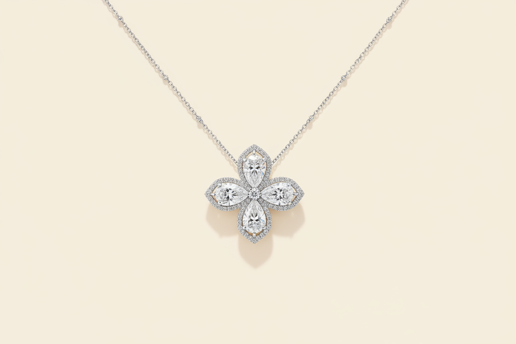 Pear-cut flower pendant necklace with white diamond finish on a warm ivory background