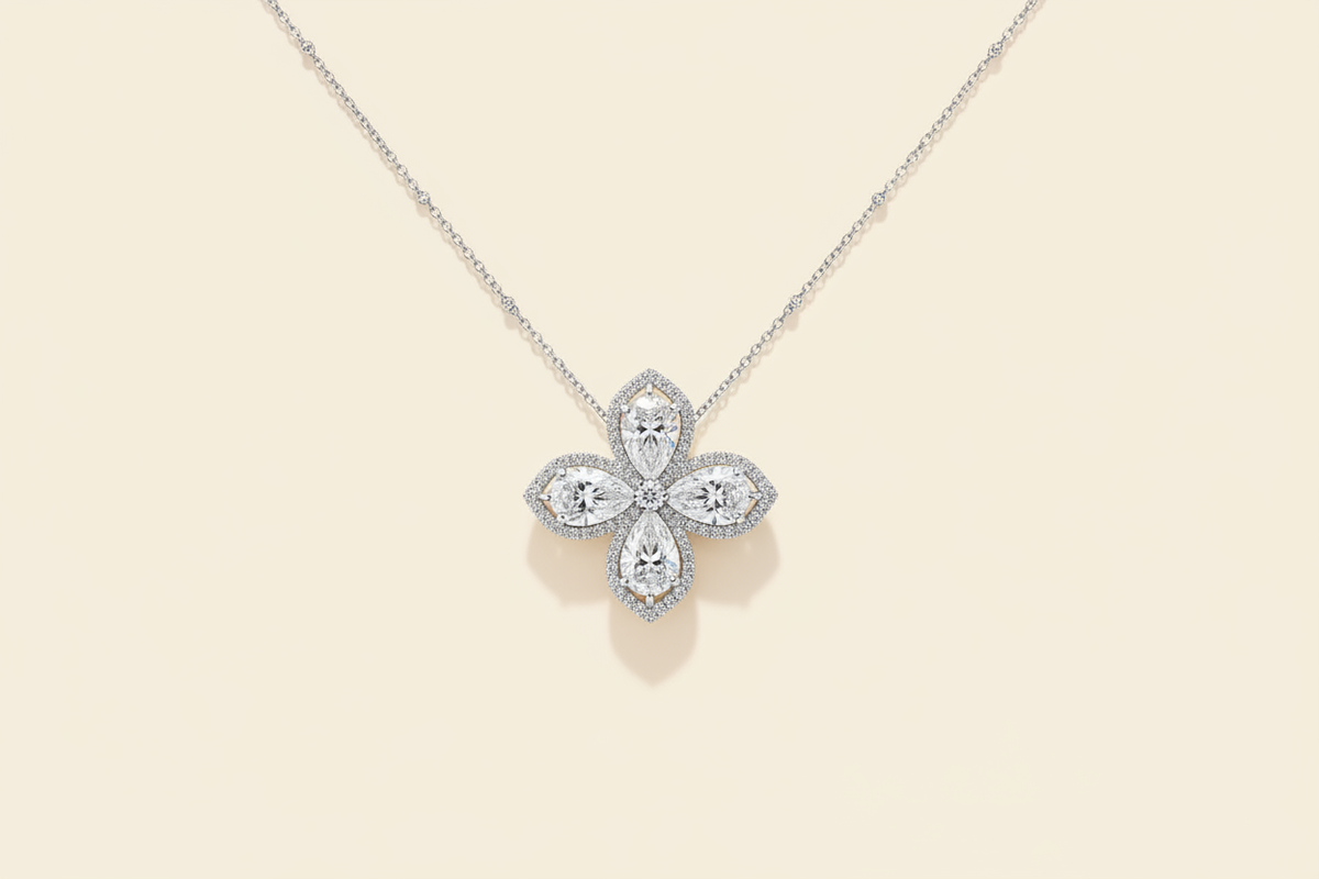 Pear-cut flower pendant necklace with white diamond finish on a warm ivory background