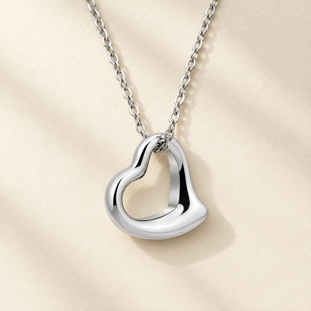 Silver open heart pendant necklace on warm ivory background