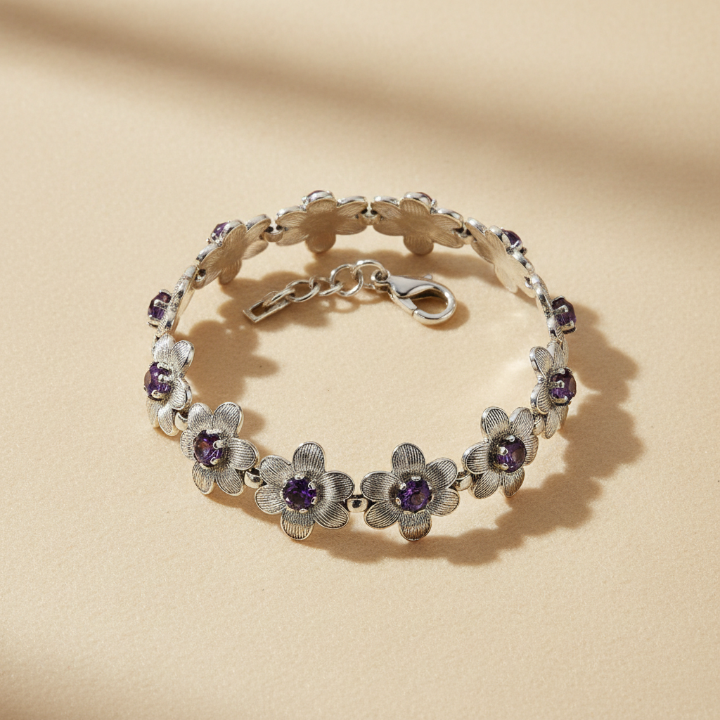 Silver-tone floral bracelet with purple stone accents on a warm ivory background