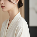 Woman wearing white pearl sunflower stud earrings with crystal floral detail