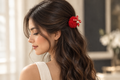 Red flower hair clip styled in wavy hair