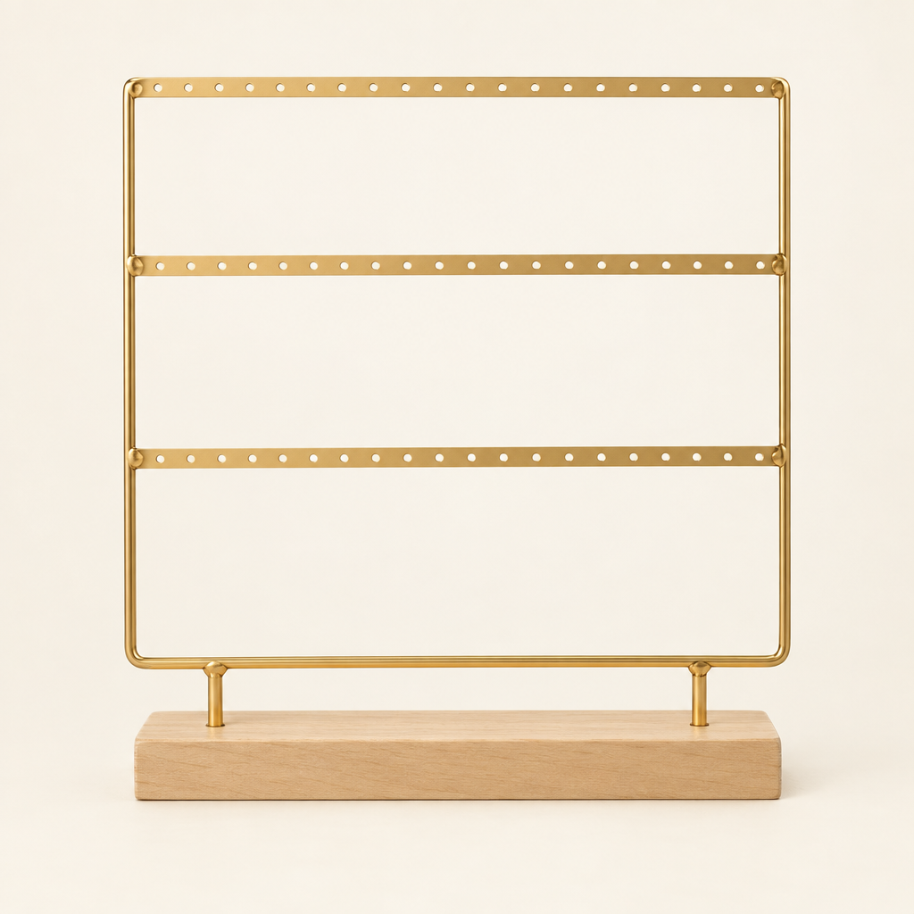 Gold-tone three-tier metal earring display stand on a light wooden base against an ivory background