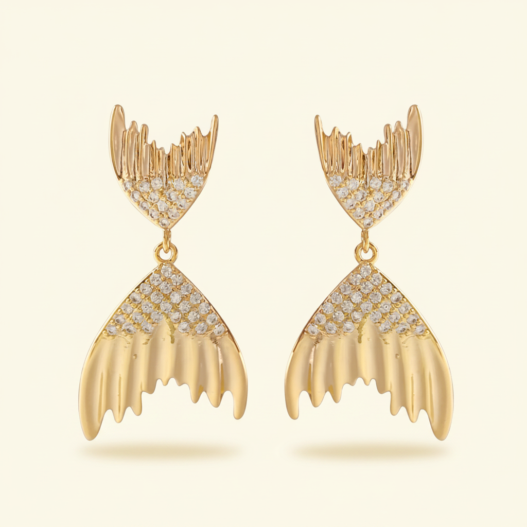 Pair of gold mermaid tail crystal drop earrings on a warm ivory background
