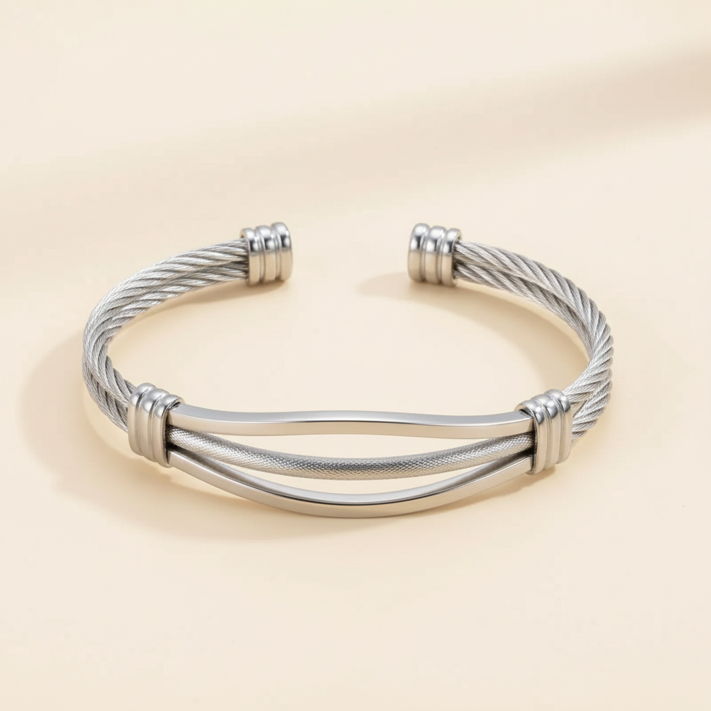 Silver braided cable open cuff bracelet on a warm ivory background
