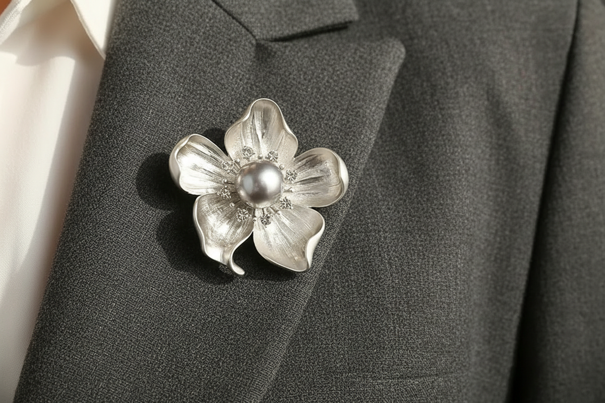 Matte silver pearl and crystal flower brooch pinned to charcoal tailored fabric