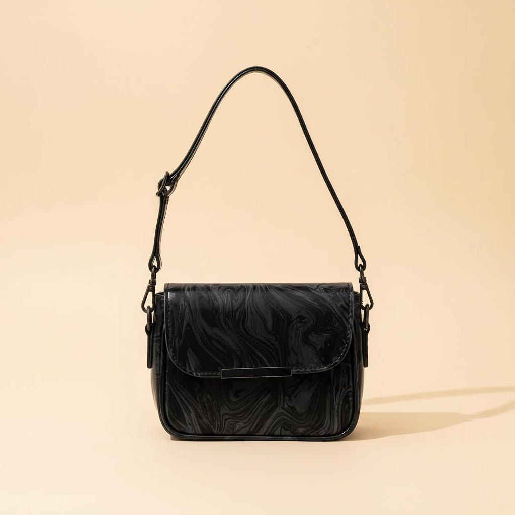 Black leather shoulder bag with adjustable strap on a warm ivory background