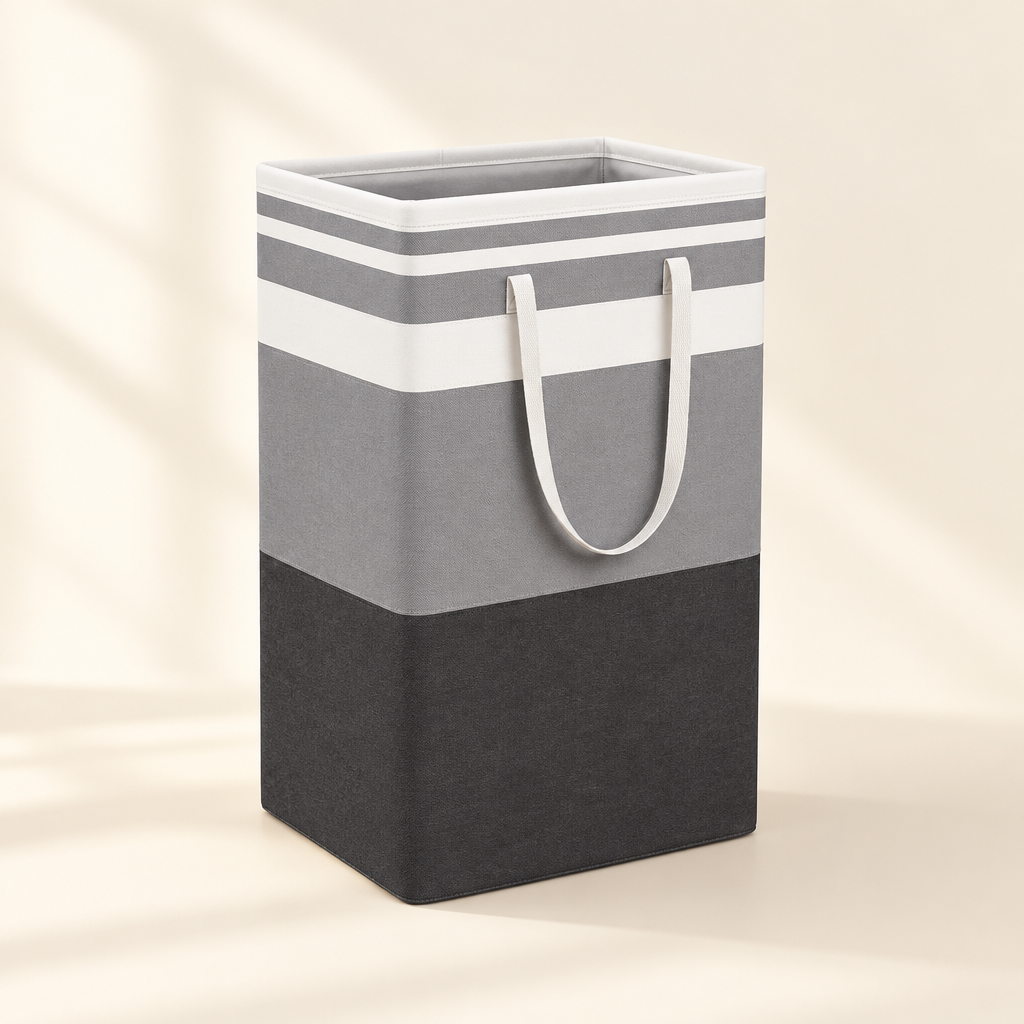 Grey and white striped foldable laundry basket with white handles on ivory backdrop