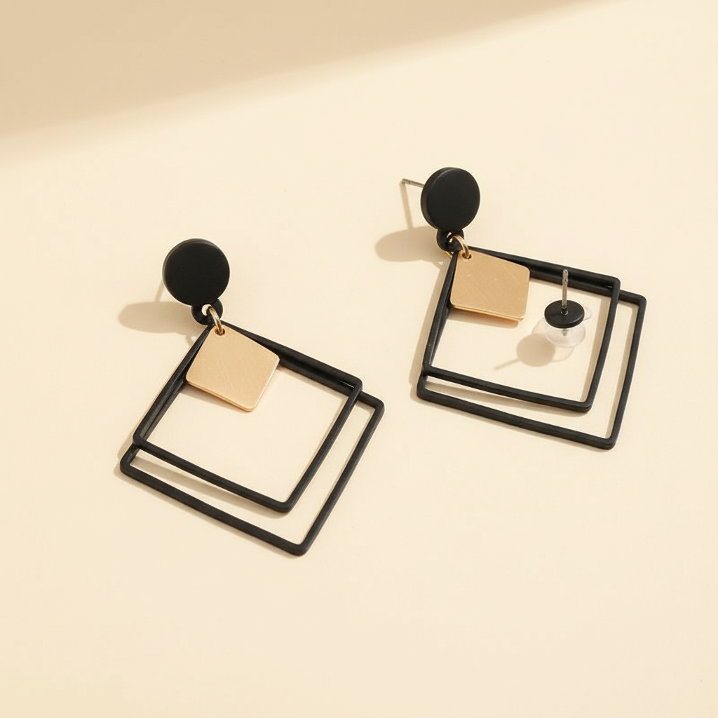 Angled detail view of black and gold geometric square earrings showing the open-frame design
