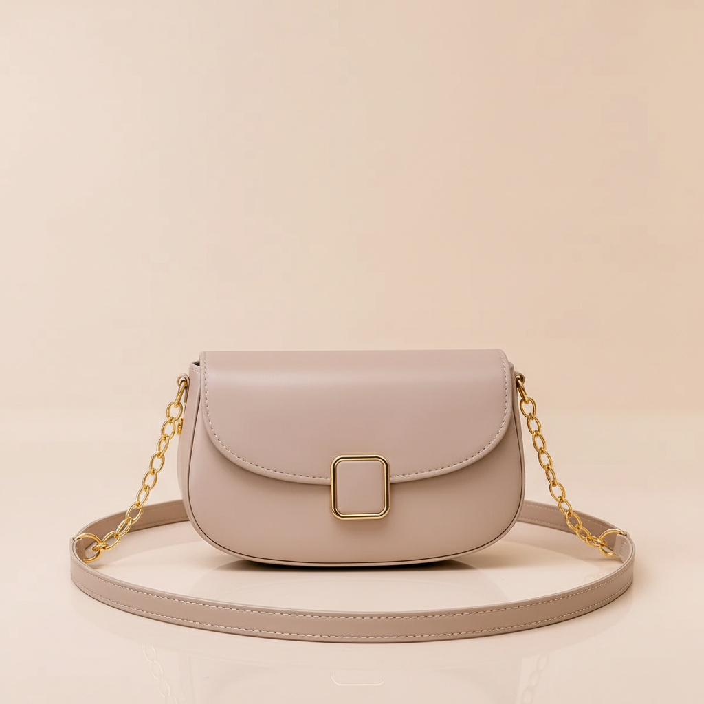 Beige leather shoulder bag with rounded flap, rectangular clasp and chain strap on a warm ivory background