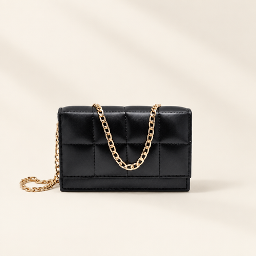 TAJIO black quilted crossbody bag with gold chain strap on an ivory backdrop