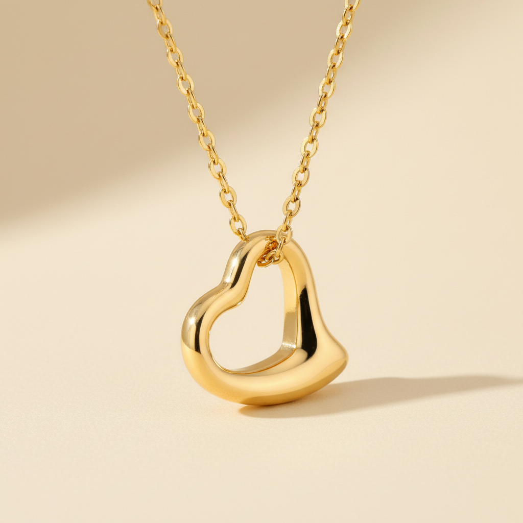 Gold stainless steel open heart pendant necklace on a warm ivory background