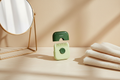 Portable multicolor hair trimmer comb beside a mirror and folded ivory towel