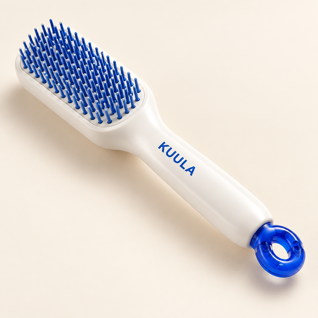Close view of white paddle hair brush with blue bristles and blue push mechanism