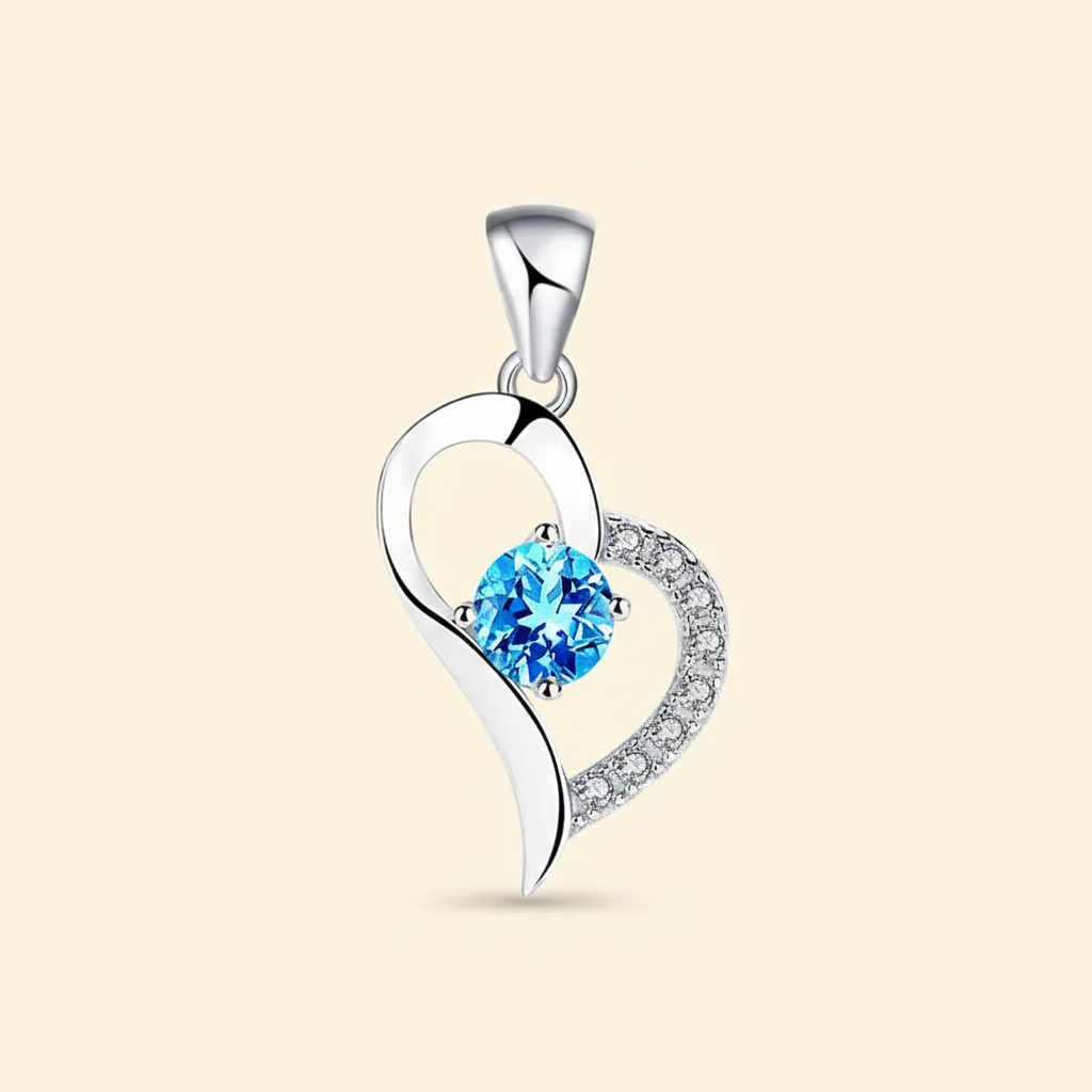 Silver-tone heart pendant with a vivid blue faceted center stone on a warm ivory background