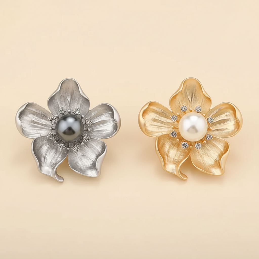 Pearl and crystal flower brooch shown in matte silver and muted gold on a warm ivory background