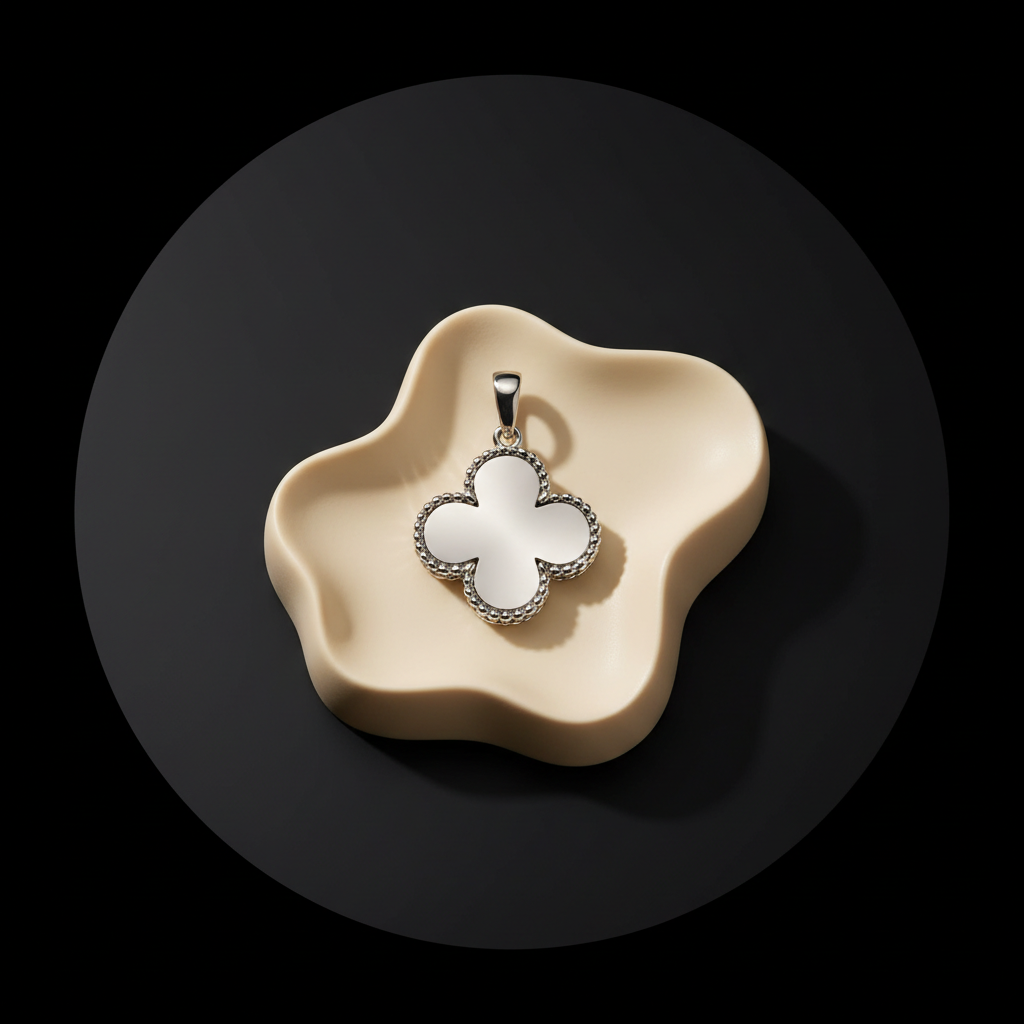 Silver four-leaf clover pendant on an ivory plinth