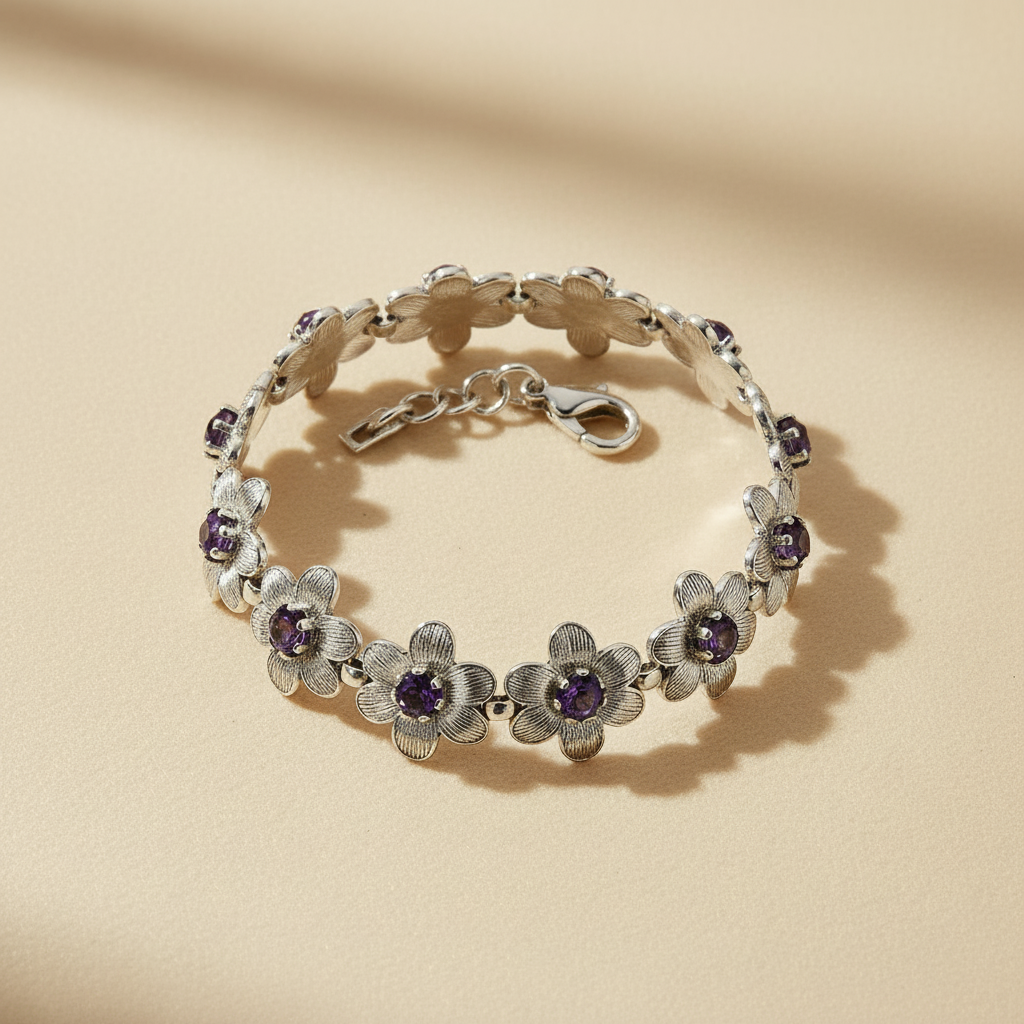 Silver-tone floral bracelet arranged in a flat lay with lobster clasp visible