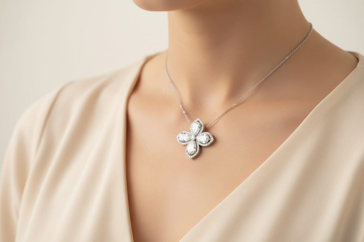 Pear-cut flower pendant necklace with white diamond finish styled on an ivory neckline