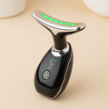 Close detail of the metallic head and controls on a black T-shaped EMS facial and neck massager