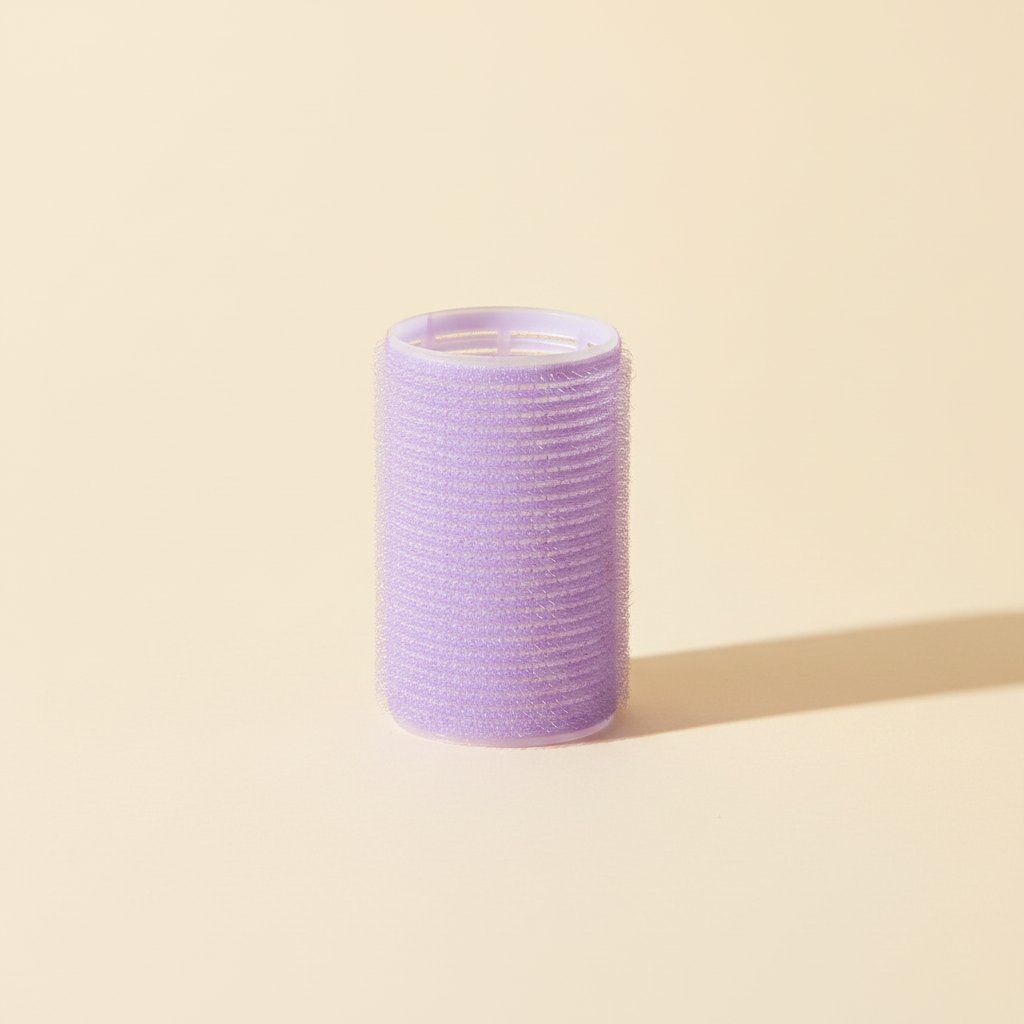 Single lavender self-grip hair curling roller with a vented plastic core and textured grip surface on a warm ivory background